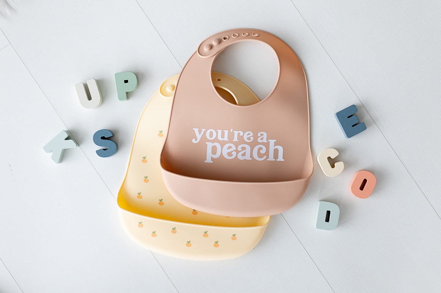 Pearhead Silicone Bib Set of 2, You're a Peach & Light Yellow Waterproof Bibs with Food Catcher, Adjustable Fit, Dishwasher Safe, Unisex Toddler Bib Set